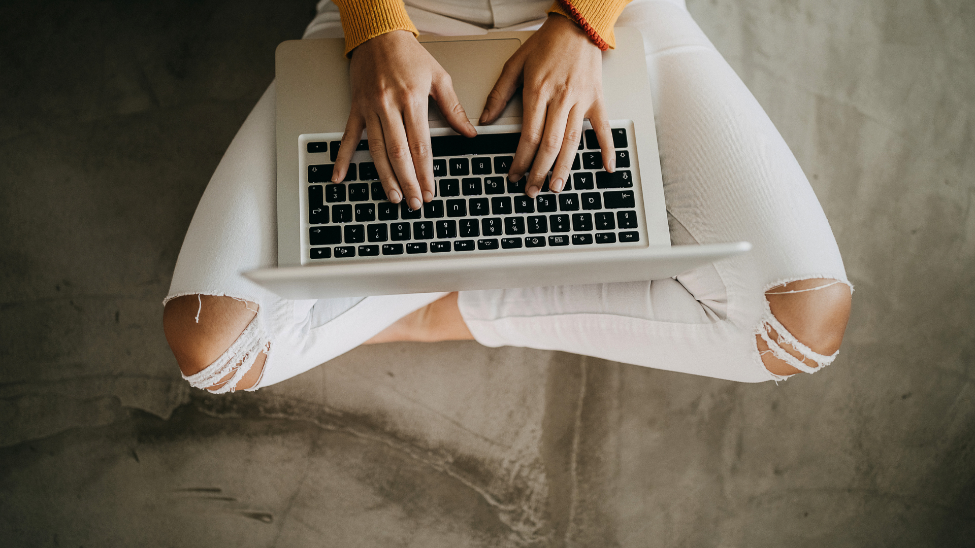 Person in lässiger Kleidung arbeitet auf einem Laptop, ein Beispiel für die Flexibilität freier Berufe.