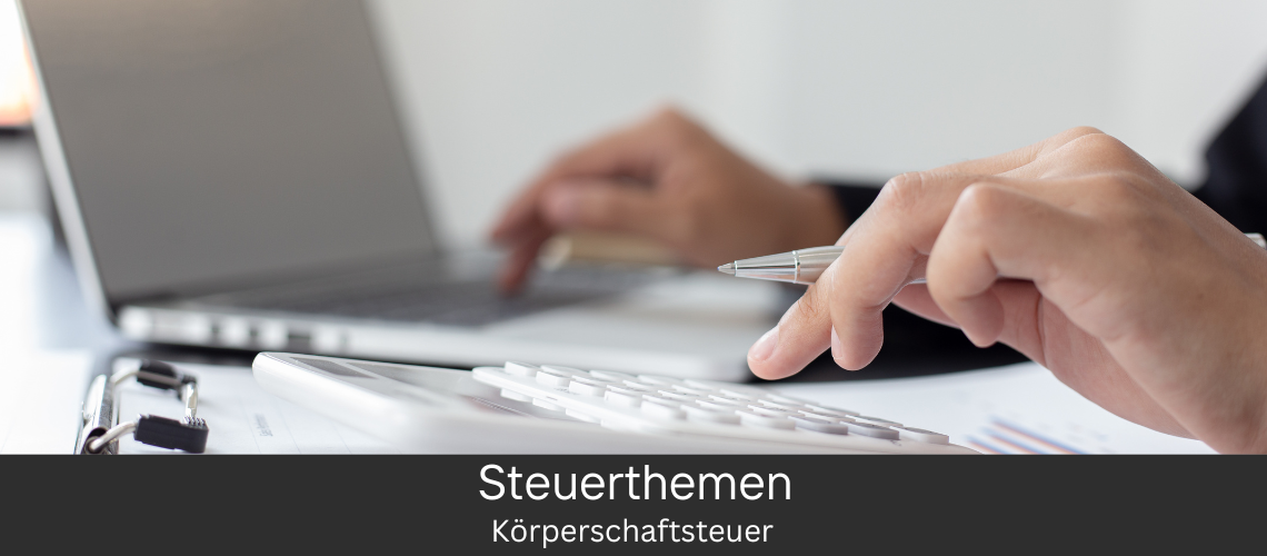 Eine Person arbeitet an einem Laptop, neben dem wichtige Unterlagen liegen, im Zusammenhang mit dem Thema Körperschaftssteuer.