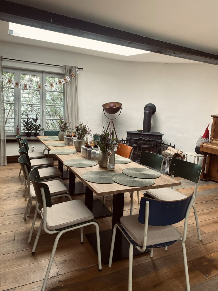 Festlich gedeckter Tisch in der Alten Sackfabrik mit rustikaler Dekoration, Kamin und Klavier im Hintergrund.