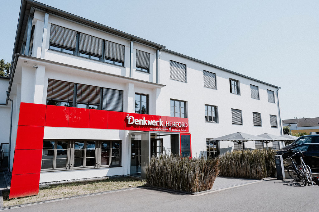 Außenansicht des Denkwerk Herford mit modernem Eingangsbereich, Coworking Space, Büroflächen und Terrasse in Herford.